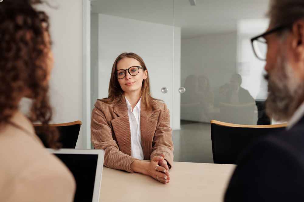 Job candidate meeting with two interviewers across a conference table